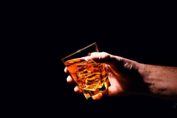 istock Whiskey glass in a hand of a man 1203880071