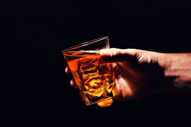 istock Whiskey glass in a hand of a man 1203880077