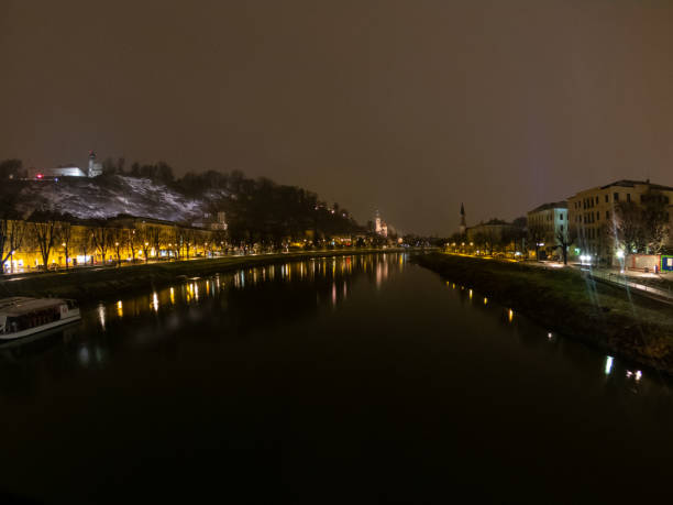 salzburgo na áustria à vista noturna de ponte sobre rio e cidade, leve reflexo na água - kapuzinerberg - fotografias e filmes do acervo