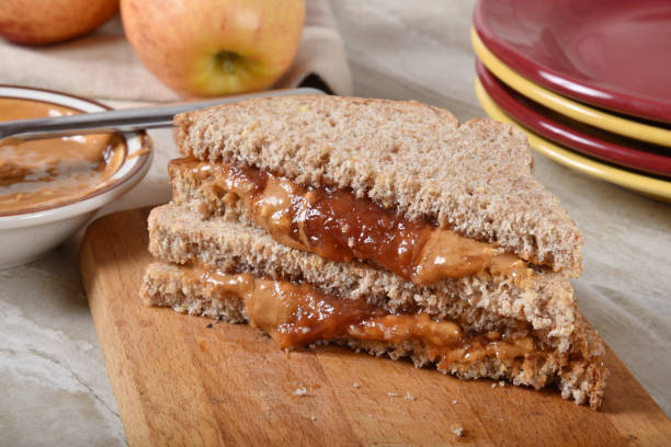 istock Sliced peanut butter and jelly sandwich on a cutting board 1203885693