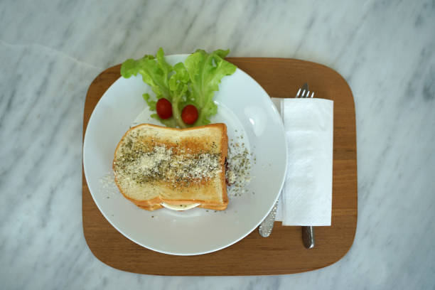 istock Fresh baked sandwich with scramble eggs and bacon serving with fresh lattice and tomato on timber plate 1203886483
