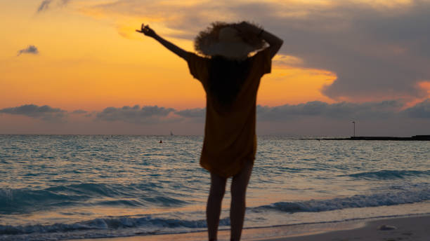 istock fit woman in straw hat with raised arms rejoicing 1203890252