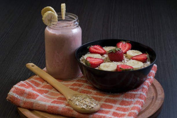 Banana strawberry and oatmeal smoothie with its ingredients stock photo
