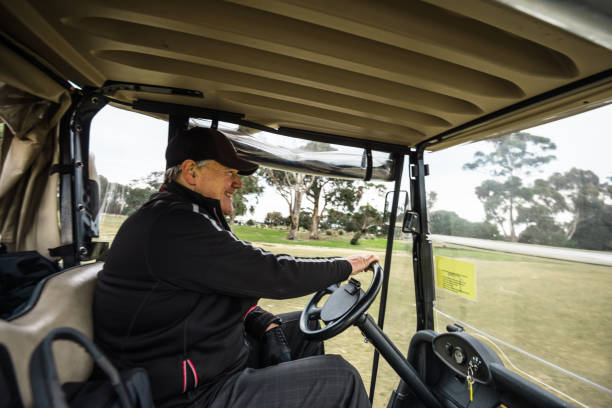 istock man driving the golf car 1203897502