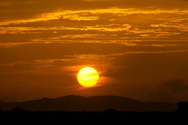 Silhouette landscape of Sunset sky with big sun and cloud.