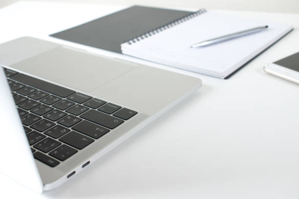 istock Office workplace with laptops, smartphones and notebooks on a white table, modern style. 1203903206