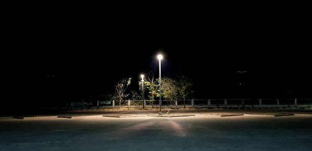 Parking Lot at Night A lone lamppost luminates the parking lot. calm before the storm photos stock pictures, royalty-free photos & images