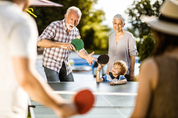 istock Happy extended family having fun while playing table tennis in the backyard. 1203904354