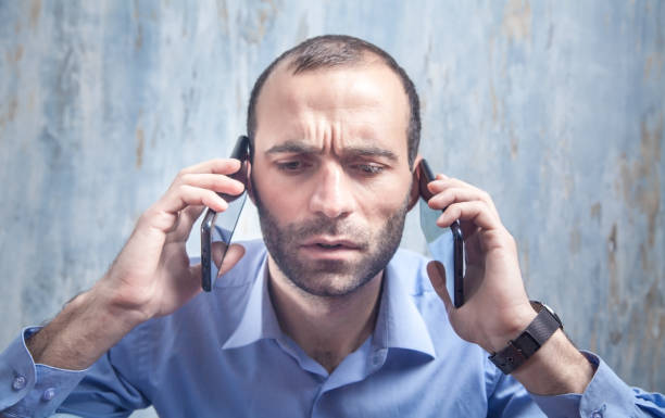 un hombre de negocios serio hablando por teléfono inteligente en la oficina. - 3504 fotografías e imágenes de stock