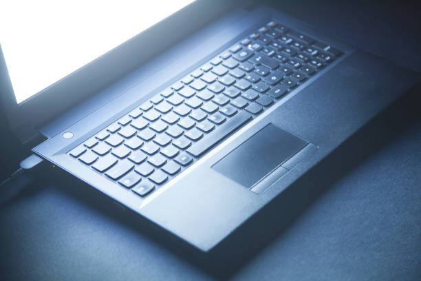 istock Black laptop on the black office desk. Technology concept 1203905470