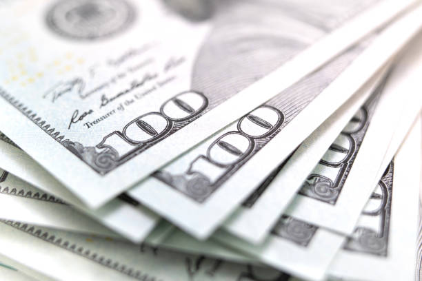 istock stack of dollars spread out. Money background 1203907518