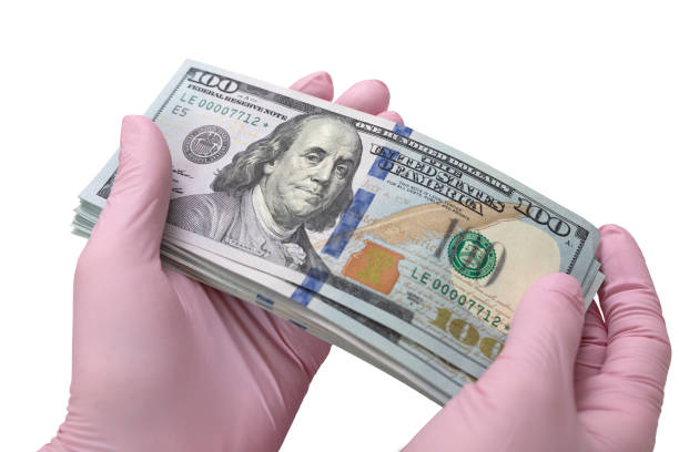 gloved hands holding a pack of dollars stock photo