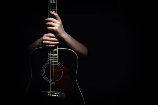 Woman Hugging With Her Hands Guitar, Isolated On Black