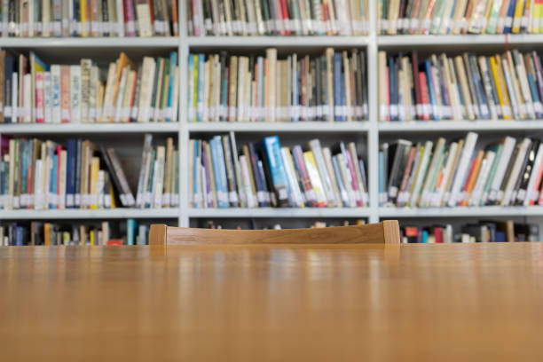 Wooden table with bookshelves in library