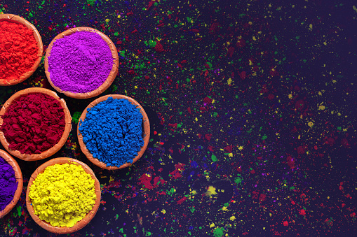 Indian Festival Holi, colors in bowl on dark background.