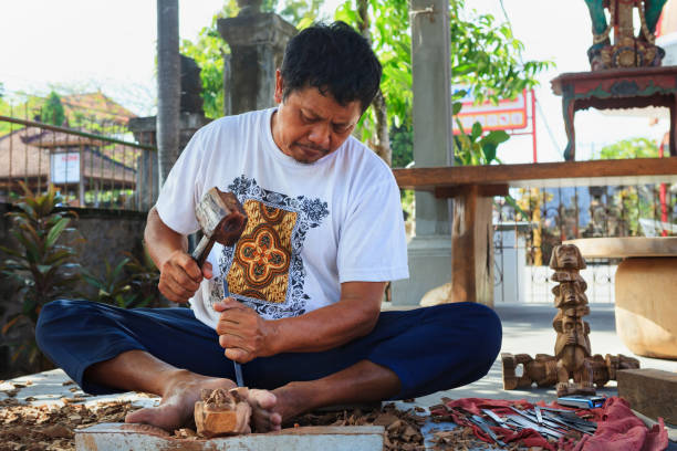 indonezyjski człowiek rzeźbienia przez ręce dekoracyjne rzeźby z drewna tekowego - bali balinese culture art carving zdjęcia i obrazy z banku zdjęć