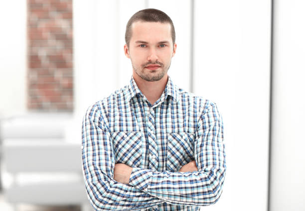 istock young employee standing next to office window 1203915486