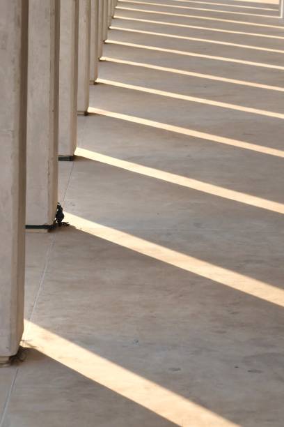 istock A line of high modern building on the path floor with sunlight shadow 1203916699