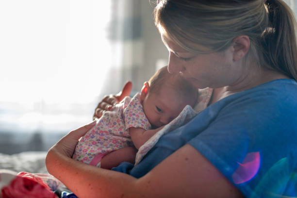 istock Side View Of Mother Carrying Daughter 1203918106