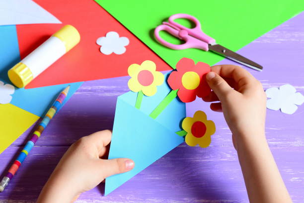 8 march card. 8 march card ideas. 8 march card ideas paper crafts. 8 march card diy. 8 march cards handmade. 8 march crafts. 8 march crafts for kids. Mothers day crafts. Easy Mothers day crafts. Birthday gifts. Easy homemade gifts. Mothers day crafts to make. Paper crafts cards. Papercraft projects. Craft for mom. Craft for mom from kids. Birthday craft for mom. Mother's day DIY cards. Mother day cards diy easy. Mother day cards diy kids el niño pequeño hace manualidades de papel para el día de la madre o el cumpleaños. niño pequeño haciendo flores de papel para mamá. simple y agradable idea de regalo. tijeras, pegamento, plantillas de flores, lápiz sobre una mesa de madera