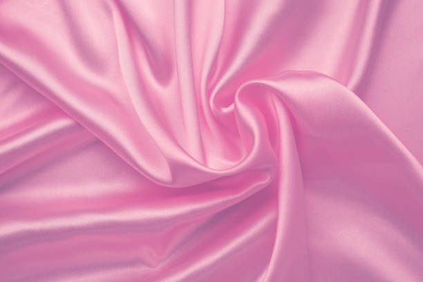 istock Pink silky background, abstract luxury textile texture. Purple smooth shiny fabric. Wavy satiny wallpaper. Romantic pink pattern on Valentine's Day. 1203918747
