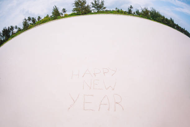 istock Happy New Year written in the white sand 1203919576