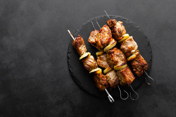 Grilled meat skewers, shish kebab on black background, top view Grilled meat skewers, shish kebab on black background, top view kebab stock pictures, royalty-free photos & images