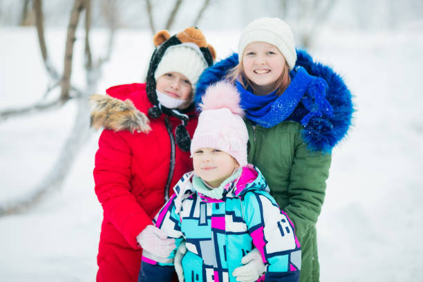 istock Three little girls sisters outdoors on a sunny winter day 1203920492