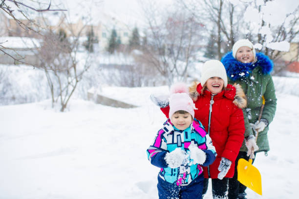 istock Three little girls sisters playing outdoors on a sunny winter day. 1203920510