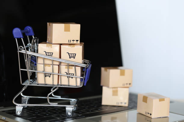 istock Brown parcel box and Model miniature shopping cart on computer keyboard for online shopping 1203921905