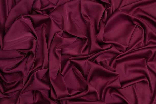istock Fabric satin silk drapery. Textile purple 1203921985
