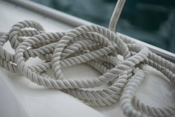 An untidy dropped docking line on deck of a sail boa