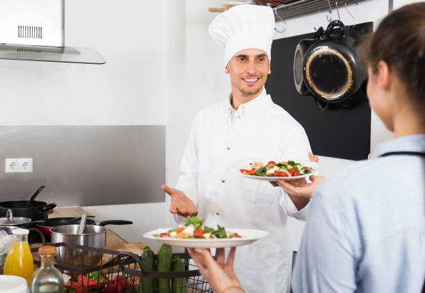 istock Adult waitress taking served salad from chef 1203923899