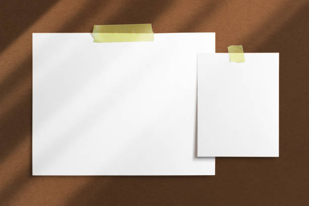 istock Mood-board composition template with blank photo cards, polaroid frames glued with yellow adhesive tape and on brown desk with geometric  shadow overlay. 1203924303