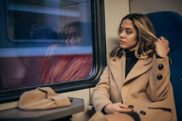 istock One woman sitting in train and looking through the window 1203924608