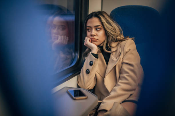 istock Woman sitting in train and looking through the window 1203924627