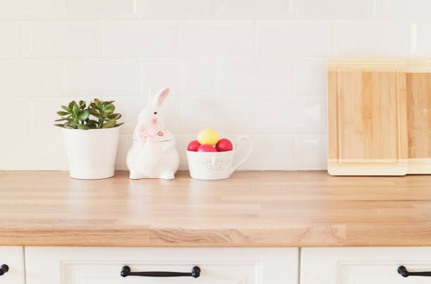 istock Easter Eggs, Rabbit, Cutting Boards, Succulent On The Kitchen Counter. Bright And Clean Rustic Kitchen With White Cabinets, Close Up. Kitchenware In Modern Kitchen Interior. White Tiles Background 1203926759