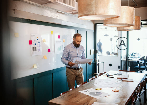 Mature businessman in smart casual clothes in meeting room Mature Latino businessmen in smart casual clothing in downtown presentation folder stock pictures, royalty-free photos & images