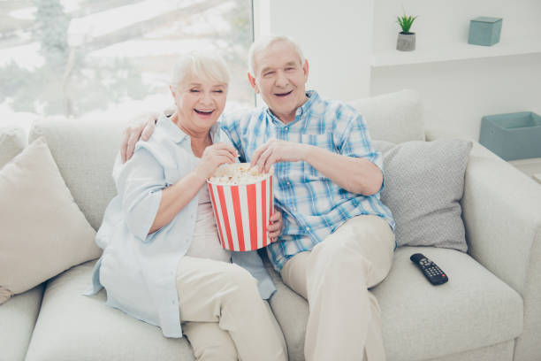 istock Above high angle view of two nice attractive cheerful cheery positive spouses having fun spending free time watching serial funny cinema in light white interior living-room indoors 1203931247