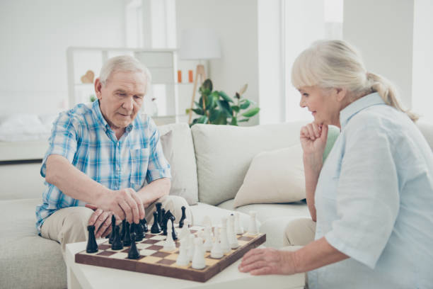 istock Profile side view portrait of her she his he two nice attractive minded bewildered concentrated focused people playing chess spending time in light white interior living-room house 1203931385