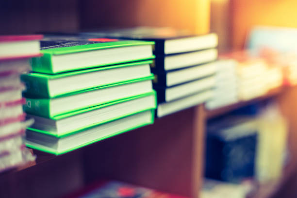 Stack of books at a charity book flea market, text space Stack of books, blurry background: Charity book flea market, indoors. Text space. benefits of reading book stock pictures, royalty-free photos & images