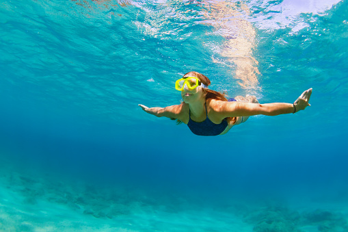 Joven activa en buceo con máscara de snorkel, nadar bajo el agua photo