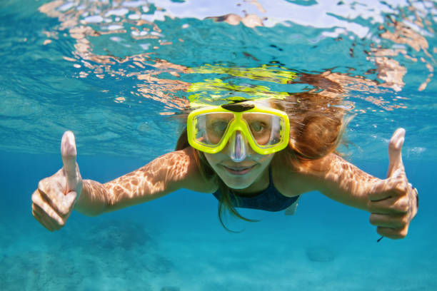 Young woman in snorkeling mask dive underwater with tropical fishes Happy family - active young woman in snorkeling mask dive underwater, see tropical fishes in coral reef sea pool. Travel adventure, swimming activity and watersports on summer beach cruise with kids. scuba diving family stock pictures, royalty-free photos & images