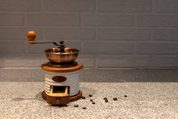 Manual coffee grinder to grind coffee beans made out of wood, ceramic and cooper on a kitchen