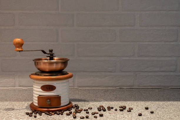 Manual coffee grinder to grind coffee beans made out of wood, ceramic and cooper on a kitchen