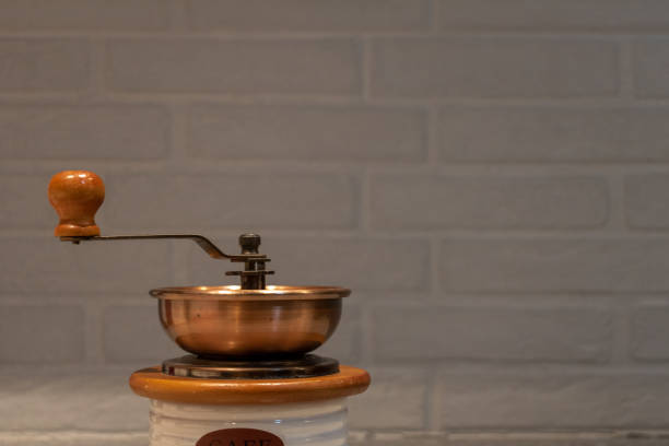 Manual coffee grinder to grind coffee beans made out of wood, ceramic and cooper on a kitchen