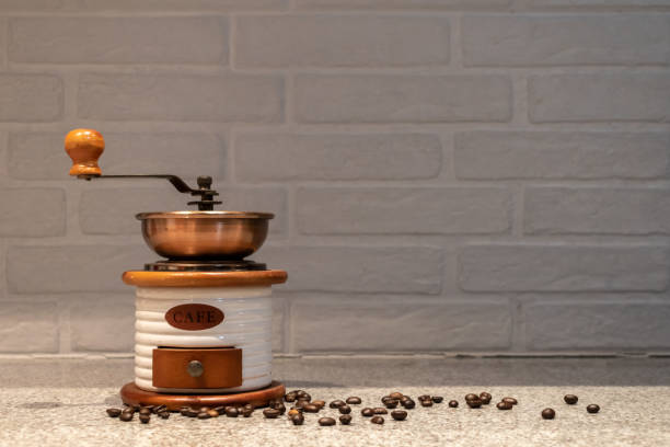 Manual coffee grinder to grind coffee beans made out of wood, ceramic and cooper on a kitchen