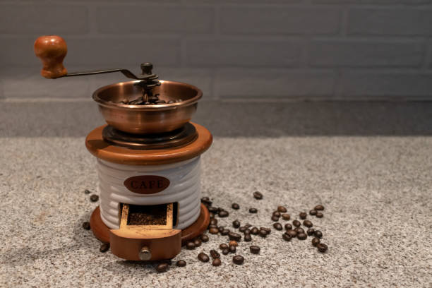 Manual coffee grinder to grind coffee beans made out of wood, ceramic and cooper on a kitchen