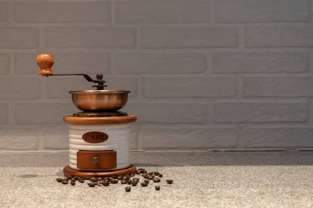 Manual coffee grinder to grind coffee beans made out of wood, ceramic and cooper on a kitchen