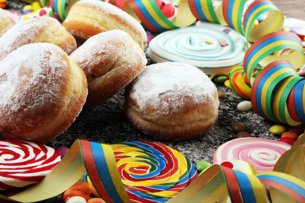 istock Carnival powdered sugar raised donuts with paper streamers. German berliner or krapfen for carnival 1203937224